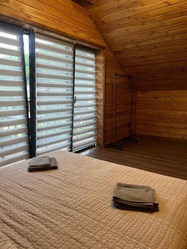 a bedroom with a large bed with two pillows on it at Foresthillсоttage in Tyshovnitsa