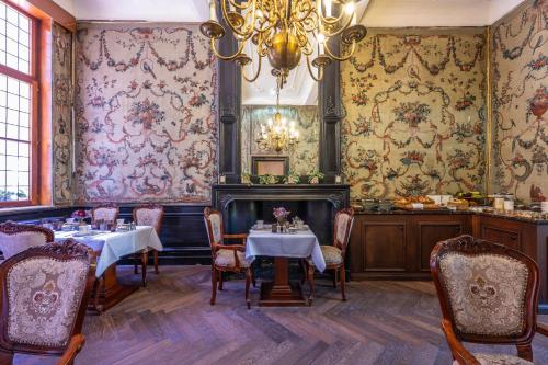 ein Esszimmer mit zwei Tischen und einem Kronleuchter in der Unterkunft Hotel Cour Saint Georges by CW Hotel Collection in Gent