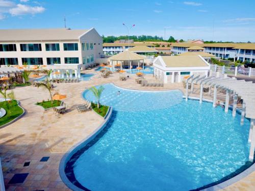 a large pool in a resort with tables and chairs at Lacqua DiRoma - Acesso livre ao Park Aquático - Central de Reservas in Caldas Novas