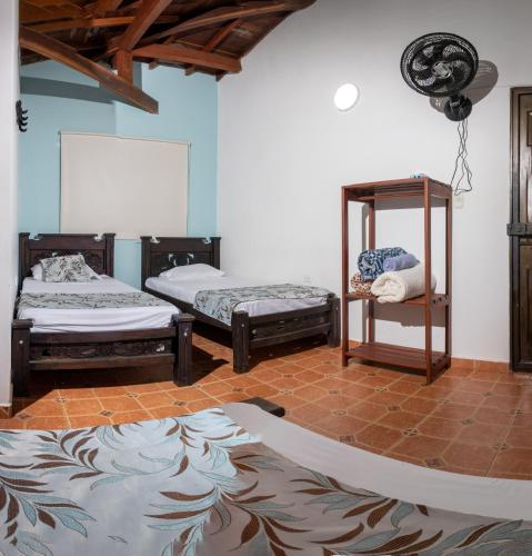 a room with three beds and a rug on the floor at Hotel para descanso con piscina in San Gil