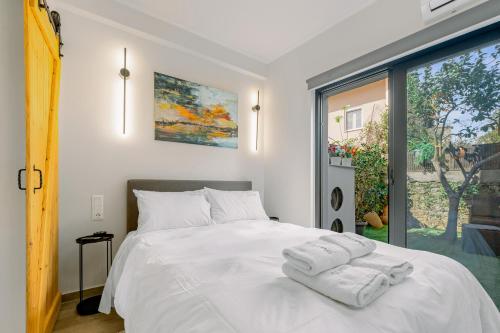 a bedroom with a white bed with towels on it at InTown Suite in Lefkada