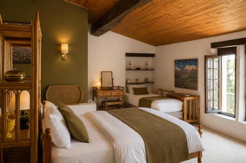 a bedroom with two beds and a desk at Le Mas de la Vivande in Marsanne