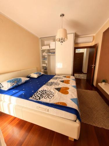 a bedroom with a bed with a blue comforter at Vista Mare Vidikovac in Budva