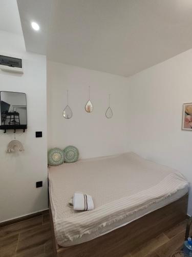 a bed in a room with white walls at Studio 714 in Škaljari