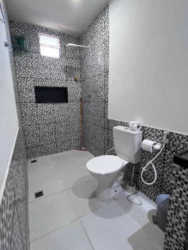 a bathroom with a toilet and a shower at Suítes Nativa in Trairi