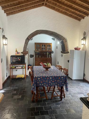 a kitchen with a table and a kitchen with a refrigerator at Robalinho's House in Faja Grande