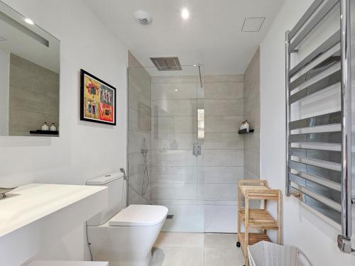 a white bathroom with a toilet and a sink at Higuerón Prestige homes in Fuengirola