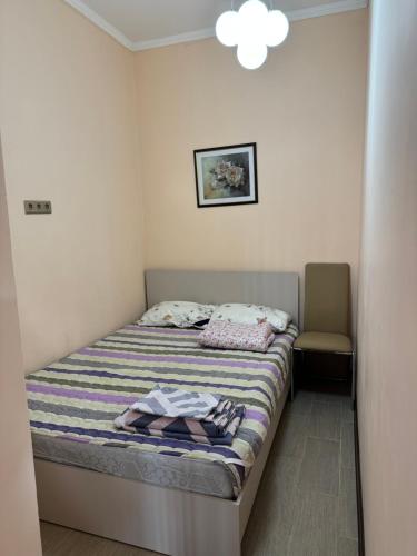 a small bedroom with a bed and a chair at MdomIK in Chok-Tal