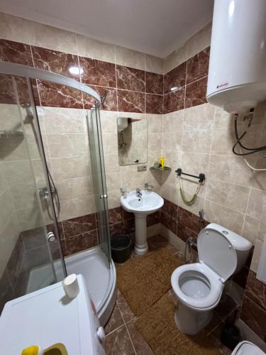 a bathroom with a toilet and a shower and a sink at MdomIK in Chok-Tal
