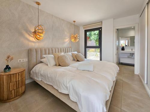 a large white bed in a room with a window at Higuerón Prestige homes in Fuengirola
