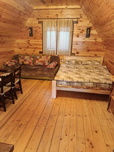 a bedroom with a bed in a log cabin at Cottage Bosaca in Žabljak