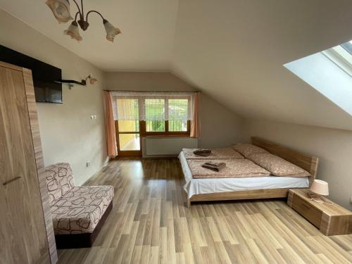 a bedroom with a bed and a couch and a window at Pension Chalupka ll with a panoramic view of Spiš Castle in Spišské Podhradie