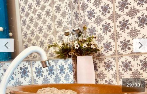 a bathroom with a sink with flowers in it at Vistamar Arco das Flores 2 in Taíba