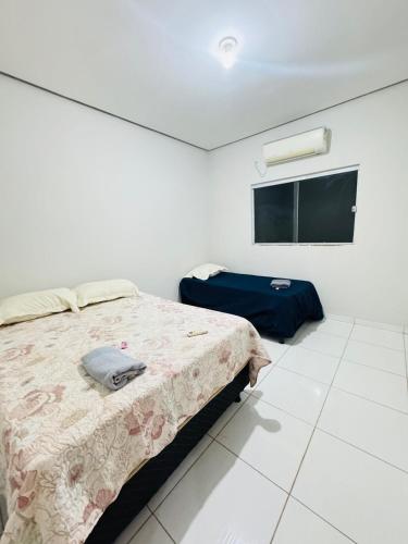 a bedroom with a bed and a flat screen tv at Casa Mobiliada Plus Gurupi in Gurupi