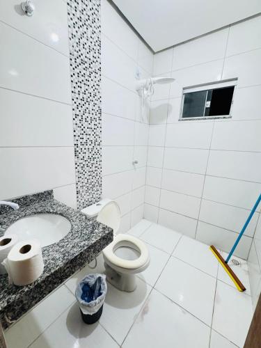 a bathroom with a toilet and a sink at Casa Mobiliada Plus Gurupi in Gurupi