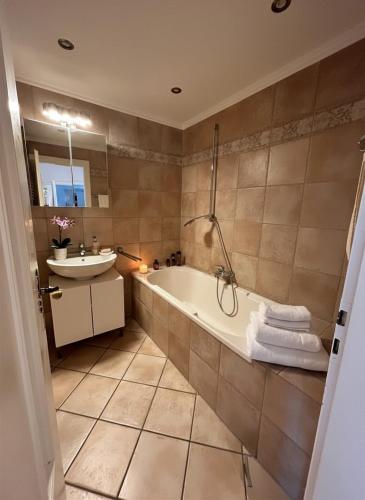 a bathroom with a tub and a sink at Midtown Apartment Hannover in Hannover