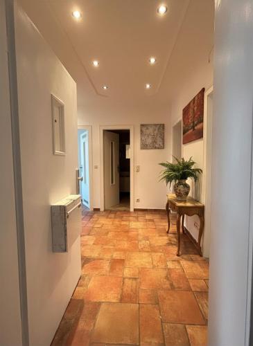 a hallway with a tile floor and a table at Midtown Apartment Hannover in Hannover