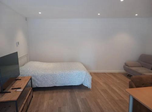 a small bedroom with a bed and a couch at Kamer Zwijnaarde in Ghent