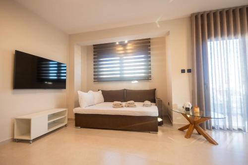 ein Schlafzimmer mit Bett, Fernseher und Tisch in der Unterkunft Kallie in Volos