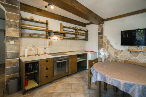 a kitchen with a sink and a table in a room at Garden Apartments Lustica in Radovici