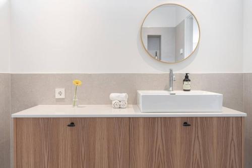 a bathroom with a white sink and a mirror at Seaside villa with pool in Simrishamn