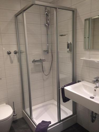a bathroom with a shower and a toilet and a sink at Hotel Lamm in Waiblingen