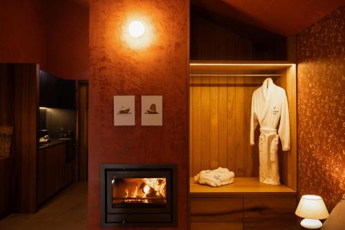 a living room with a fireplace and a robe on display at Passinhos House in Amarante