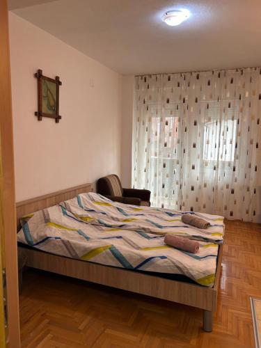 a bedroom with a bed with a chair and a window at M apartment in Ohrid