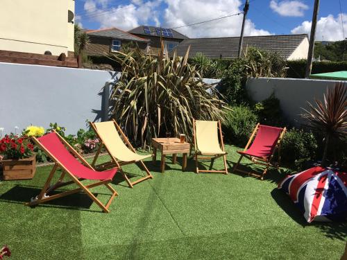 three lawn chairs and a table in a yard at Portreath Arms in Portreath