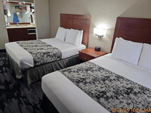a hotel room with two beds and a table at Best Western Montis Inn in Saint Robert
