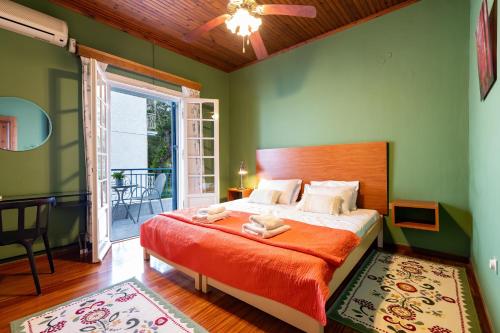 a bedroom with a bed with green walls and a window at Lemon Garden Apartments in Lygia