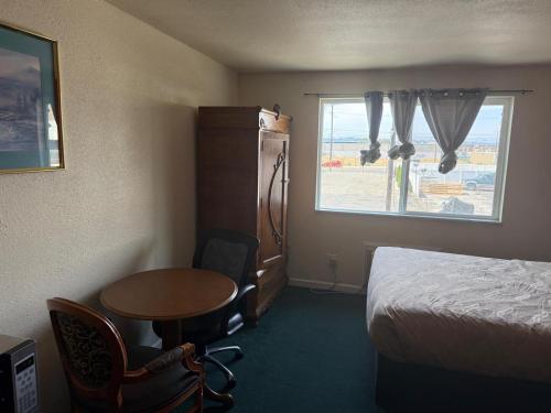 a hotel room with a bed and a table and a window at Sunshine Motel in Yakima