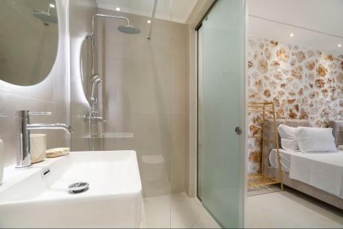 a bathroom with a sink and a shower and a bed at Goudis Luxury Villas Lefkada Sea View & Private Pools in Tsoukalades