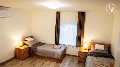 a bedroom with two beds and a window at Rezéti vendégház in Pörböly