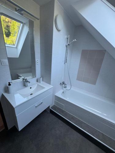 a white bathroom with a sink and a bath tub at Apartmán Lesný Dvor in Martinske Hole