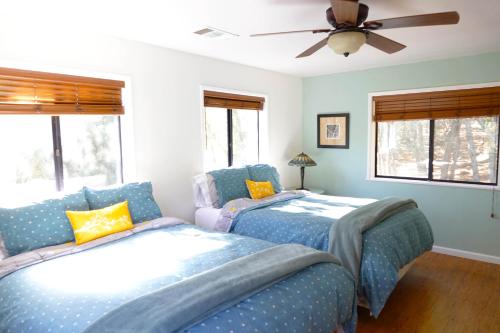 a bedroom with two beds and a ceiling fan at Pine Hills Cabin in Julian in Julian