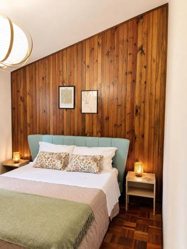 a bedroom with a bed with a wooden wall at Cà di Grè - Camigliatello Silano in Camigliatello Silano