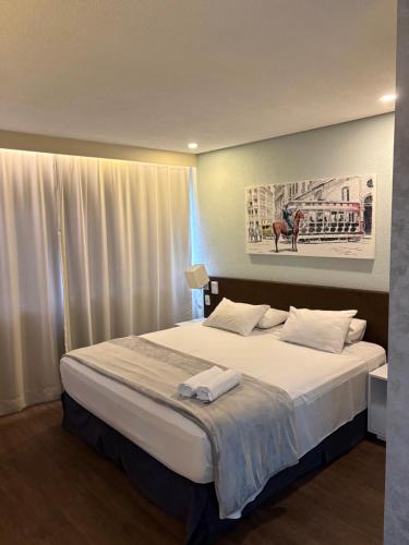a bedroom with a large bed with white sheets at Flat Fabuloso Hotel Berrini in São Paulo