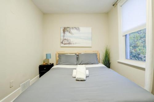 a white bedroom with a large bed with a window at JstLikeHome - Central Suite in Ottawa