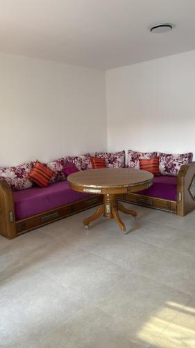 a couch with a wooden table and a purple couch at Porte de la Méditerranée in Perpignan