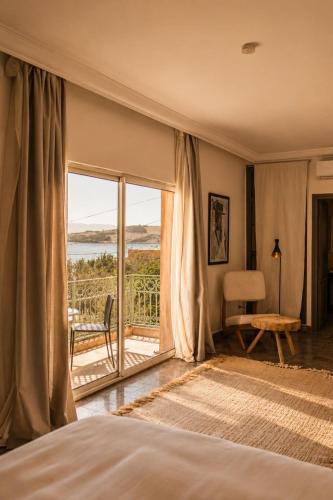a bedroom with a bed and a window with a view at Casa Lalla Hotel Rural in Douar Aguergour