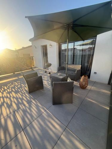 a patio with chairs and an umbrella on a building at Porte de la Méditerranée in Perpignan