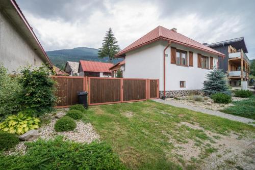 a backyard with a fence and a house at Modrý Dom - Telgárt Resort in Telgárt