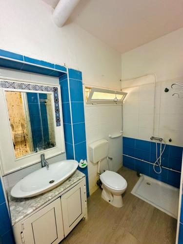 a blue and white bathroom with a toilet and a sink at Waterfront house 1 in Kelibia