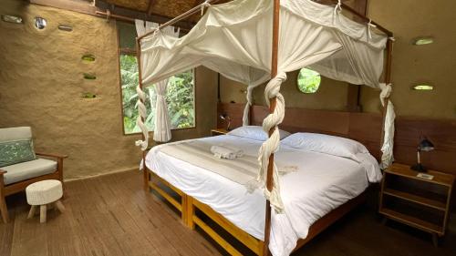 a bedroom with a four poster bed with a canopy at Chirapa Manta Amazon Lodge in Lamas