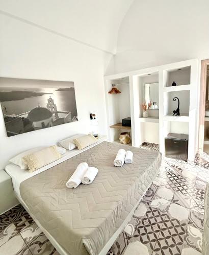 a bedroom with a large bed with towels on it at Giasemi Fira Studios in Fira
