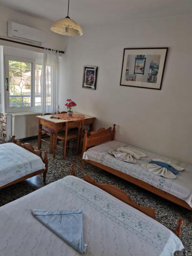 a living room with three beds and a table at Oasis in Loutrópolis Thermís