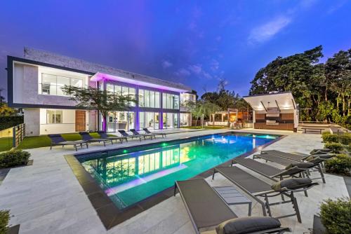 a swimming pool with chairs and a house at Luxury 9-Bedroom Villa in Southwest Ranches with Private Pool, Jacuzzi, and Movie Theater, Sleeps 20 in Miami