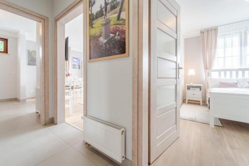 a bedroom with a refrigerator and a bed in it at Apartament Prowansalski in Nałęczów