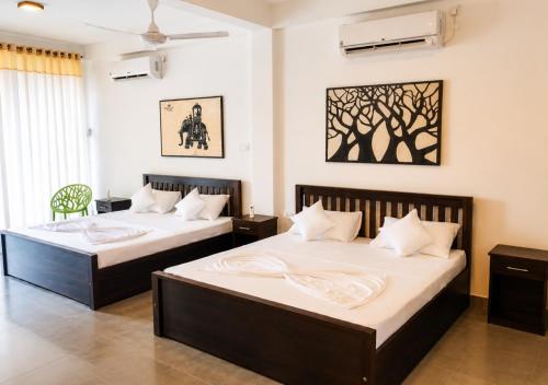 two beds in a hotel room with at Walawa Valley Rest Inn in Udawalawe